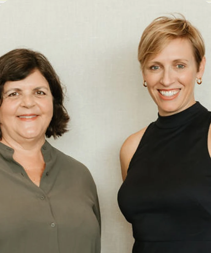 The two CLC founders standing together against a plain wall